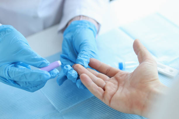 Clinician performing a fingertip blood sample for point-of-care INR testing